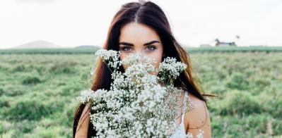 Woman smelling flowers, Mackay, Australia.